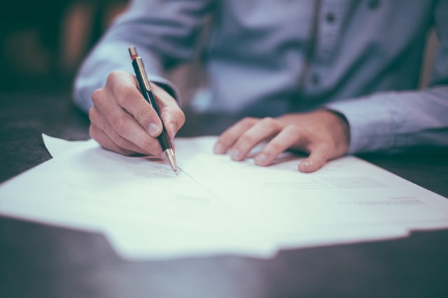 Someone signing a document.